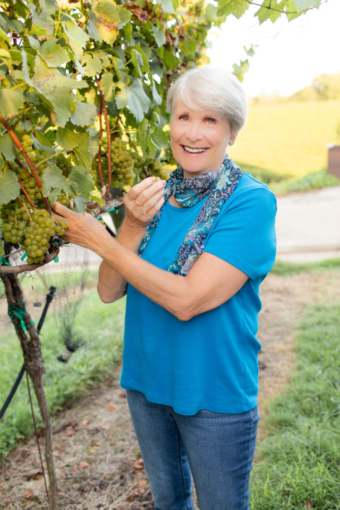 woman enjoying grape in vineyard