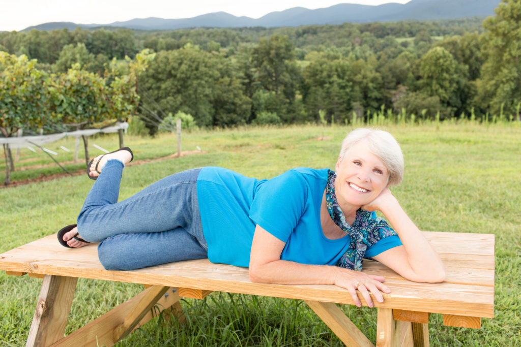 woman on picnic table with mountains in the background
